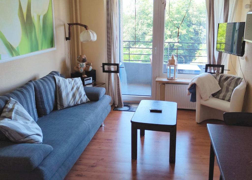 uma sala de estar com um sofá azul e uma mesa em Appartement Tim em Glücksburg