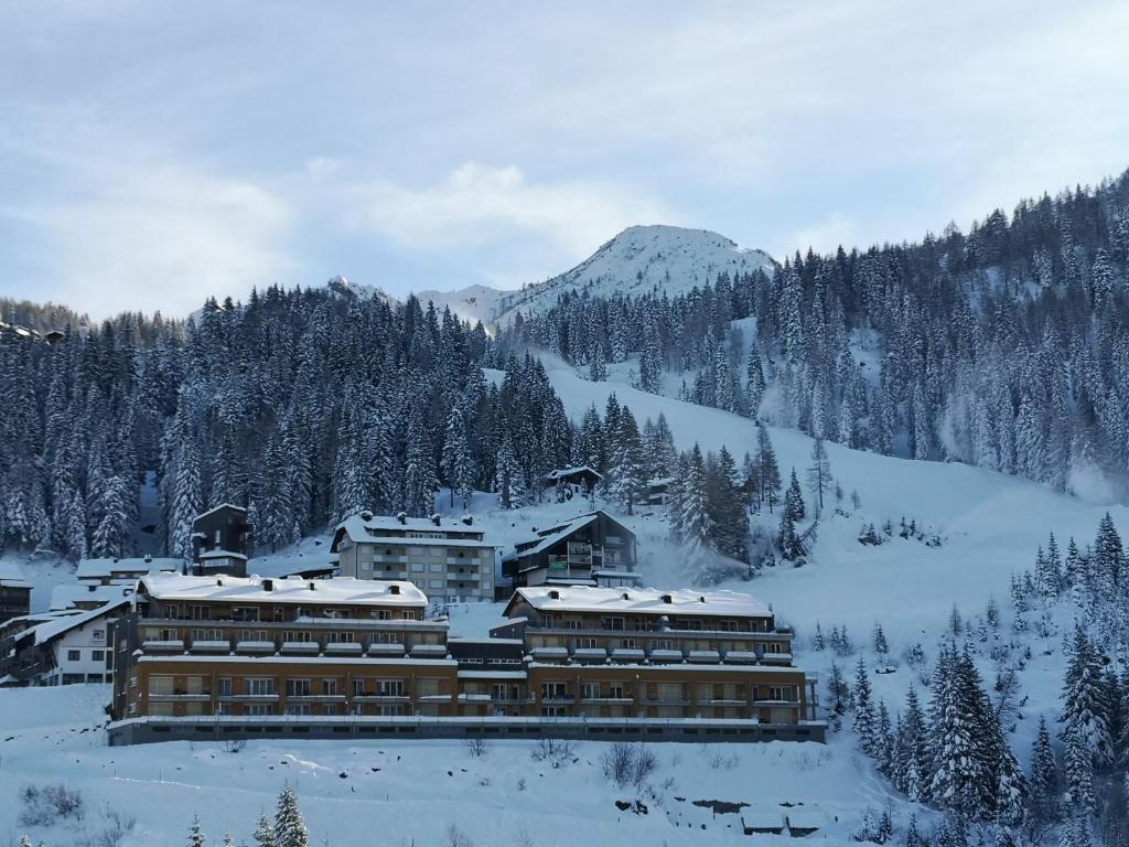 ein großes Gebäude im Schnee auf einem Berg in der Unterkunft Sonnenalpe Apartments Nassfeld in Sonnenalpe Nassfeld