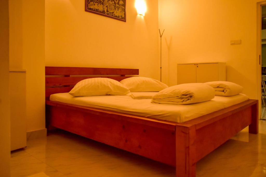 een slaapkamer met een bed met witte lakens en kussens bij Nature Lanka Guest House in Negombo
