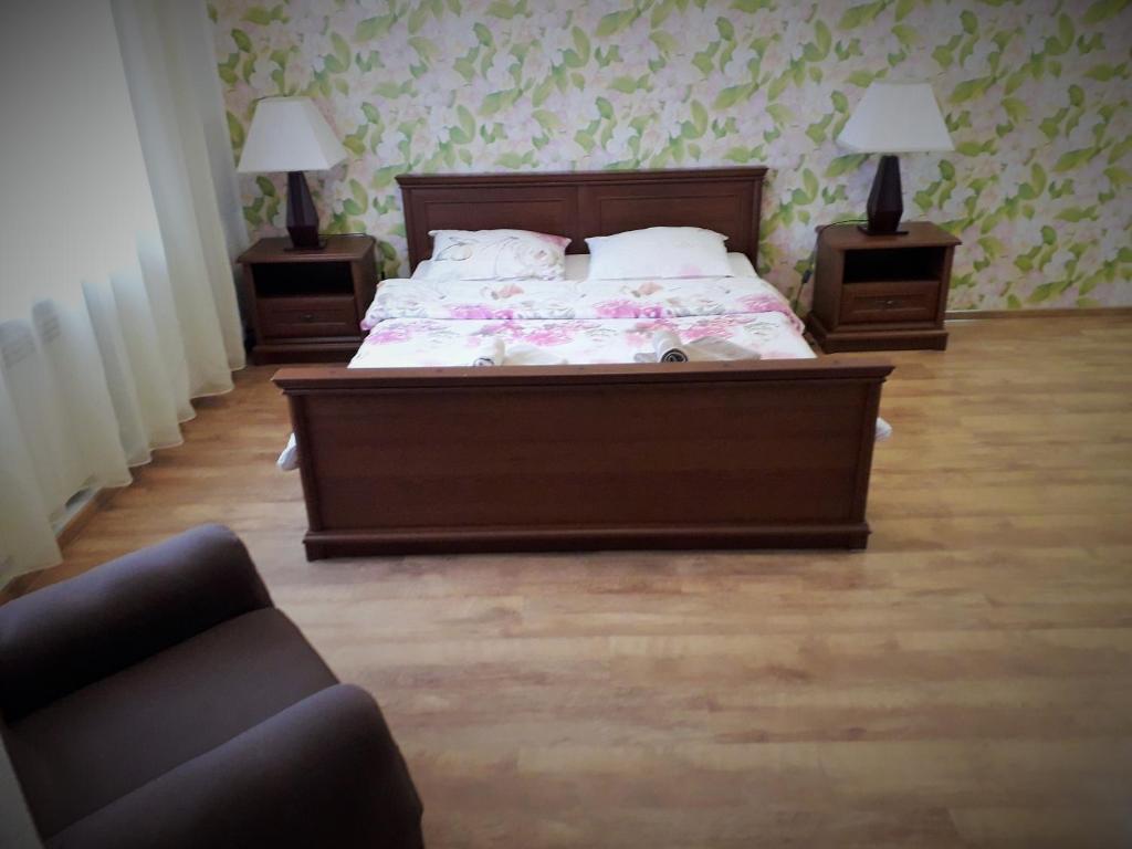 Novyye PetrovtsyにあるGuest house on Ivana Frankaのベッドルーム1室(ベッド1台、ナイトスタンド2台、ソファ付)