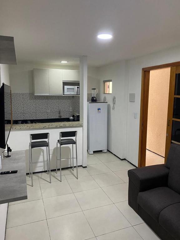 a living room with a couch and a kitchen at Pousada Residencial Milagre 01 in Juazeiro do Norte