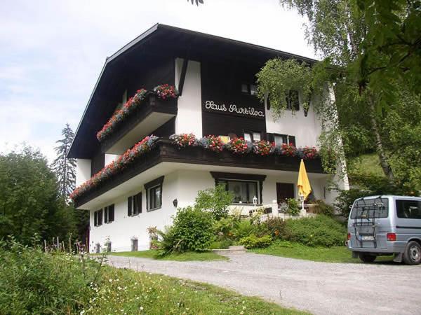 een gebouw met bloemen aan de zijkant bij Pension Sursilva in Gargellen