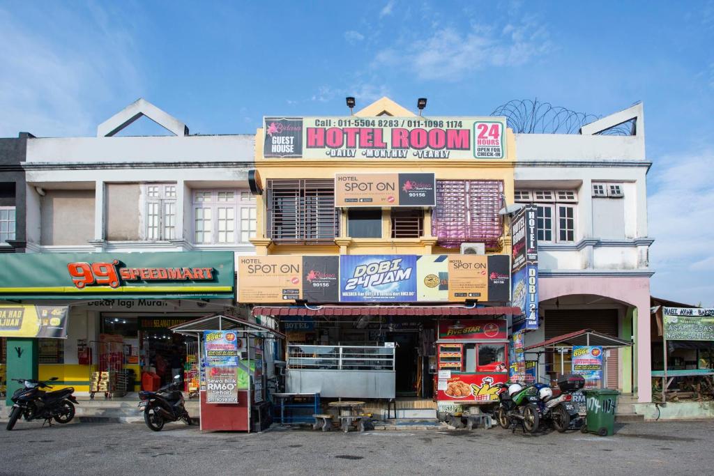 een gebouw met motoren die ervoor geparkeerd staan bij SPOT ON 90156 Bidara Guest House in Melaka