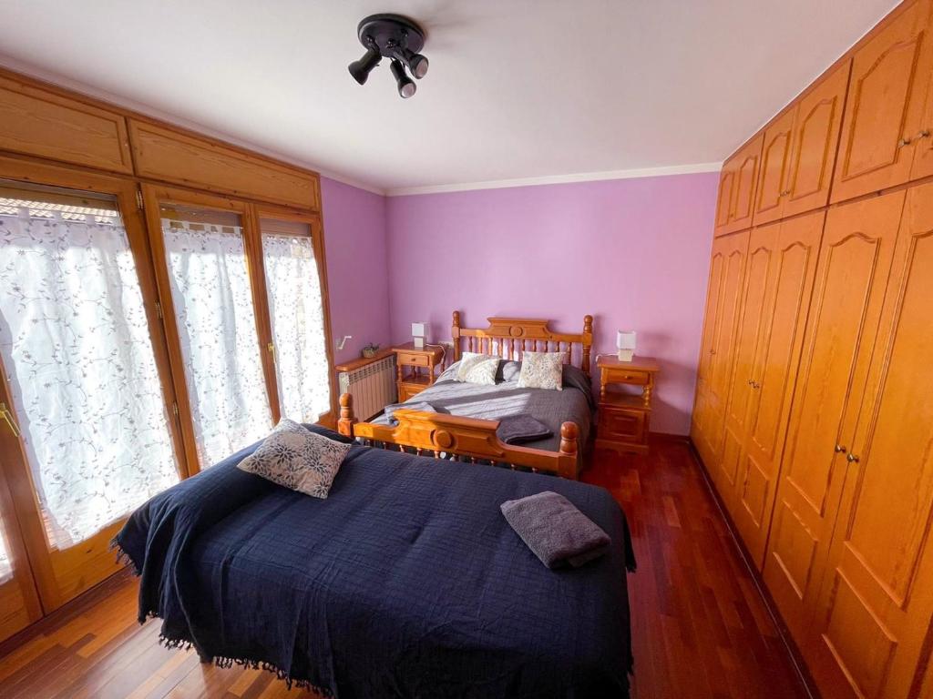 1 dormitorio con paredes moradas y 1 cama en él en Cal Patola Xic, en Bagá
