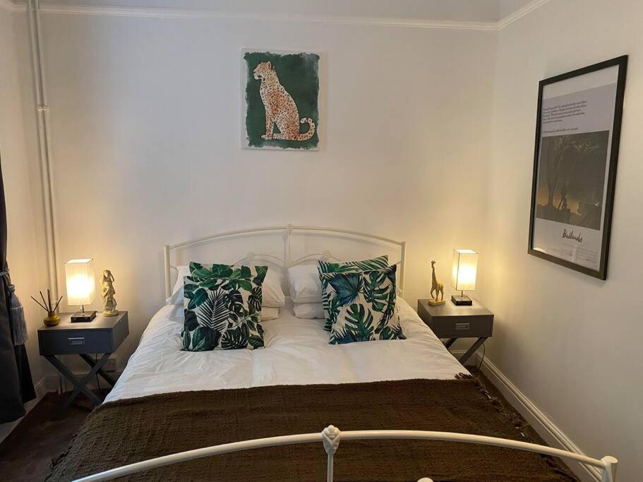 Cosy Regency Studio Apartment في برايتون أند هوف: غرفة نوم بسرير ومخدات ومصباحين