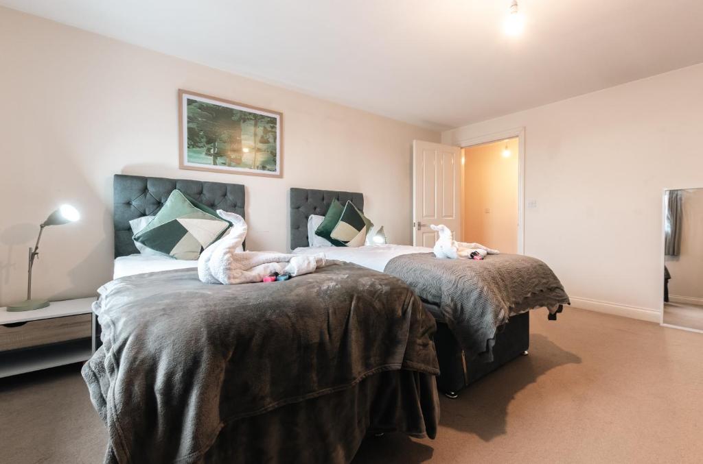 a bedroom with two beds with animals laying on them at BEST PRICE! - HUGE 3 Bed 2 Bath City Centre Top Floor Apartment, Up to 10 guests - FREE SECURE PARKING - SMART TV - SINGLES OR KING SIZE BEDS in Southampton