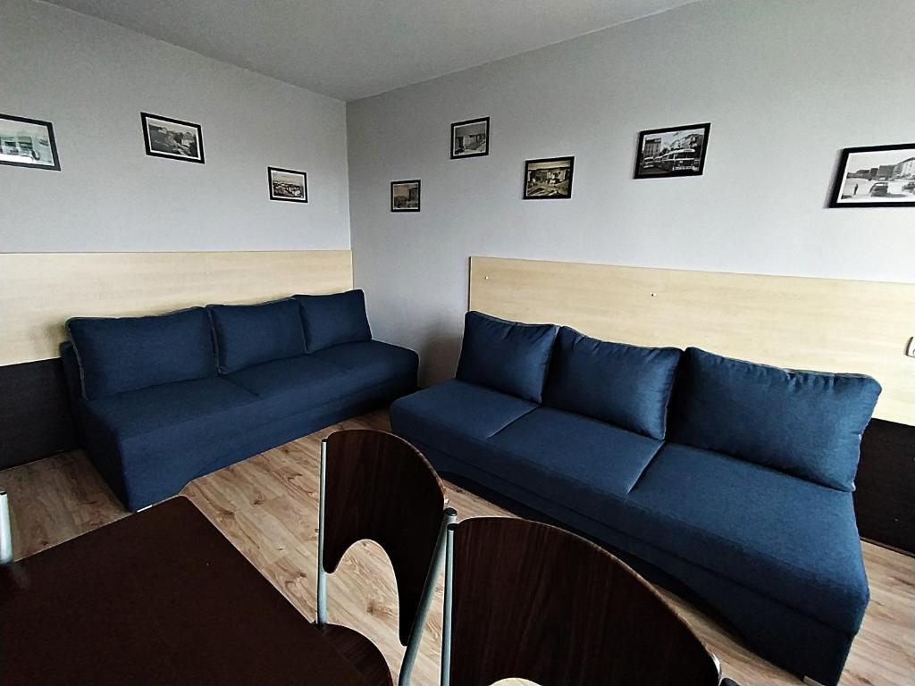 a living room with blue couches and a table at NoclegwGdyni24 in Gdynia