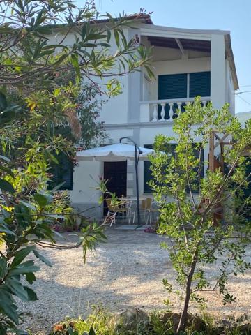 una casa bianca con un tavolo e sedie di fronte di Isola d'Elba casa vacanze - Villa Portello - magnetite - la casina a Rio Marina