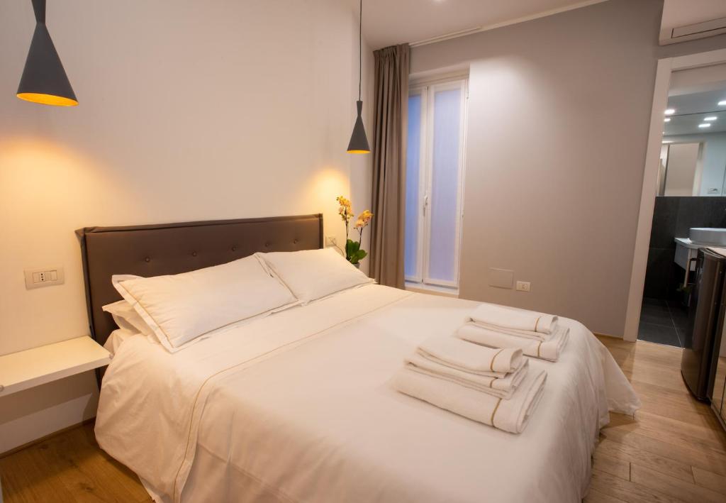 a bedroom with a large white bed with towels on it at Bamboo Milano Sinatra Apartment in Milan