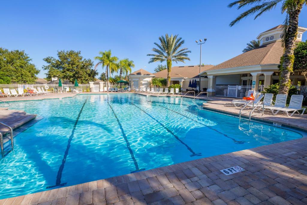 una piscina con agua azul y palmeras en The Great Escape - A spacious 1st floor condo on Windsor Palms Resort - close to Disney, en Kissimmee