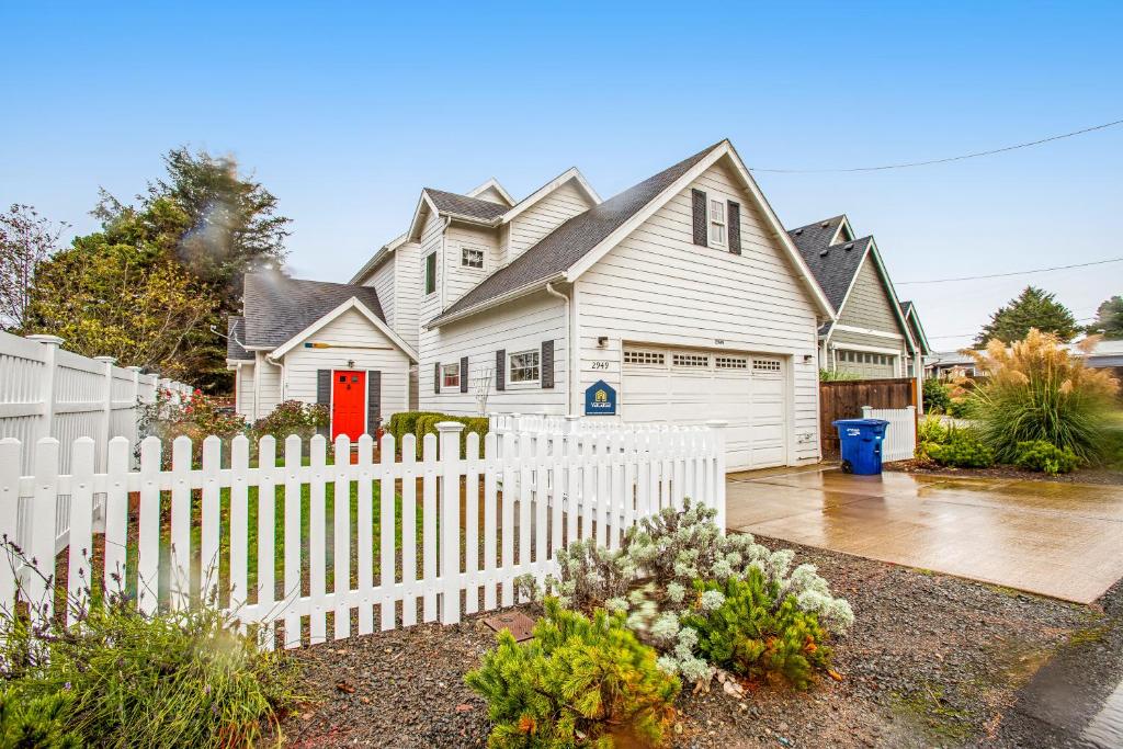 a white picket fence in front of a house at WindRose in Lincoln City