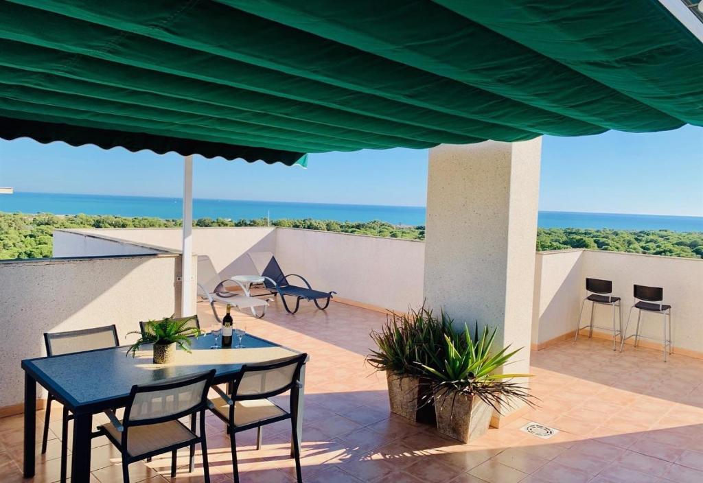 a patio with a table and chairs and the ocean at Penthouse with stunning views in Guardamar del Segura