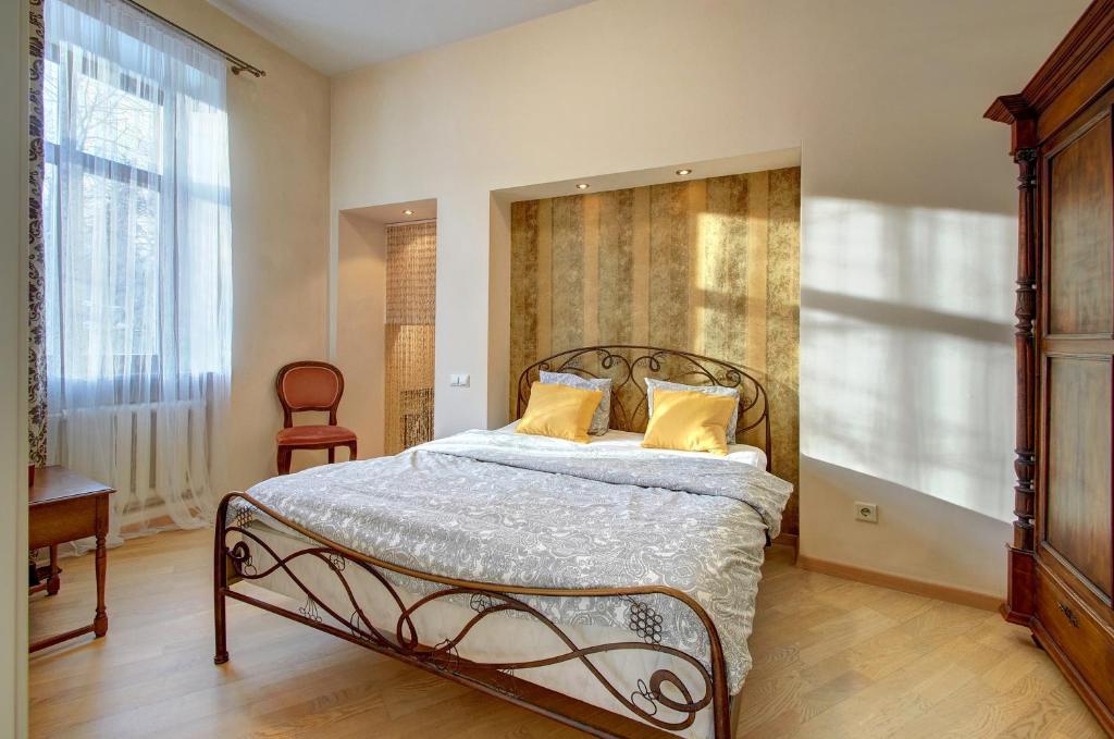 a bedroom with a bed with two yellow pillows at Romantic City Center Apartment in Old Town in Vilnius