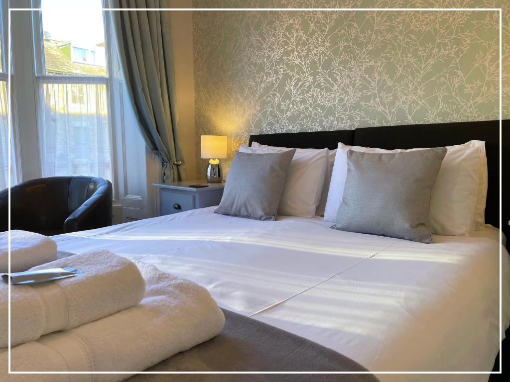 a bedroom with a white bed with pillows and a window at Smugglers Rest Bed & Breakfast in Whitby