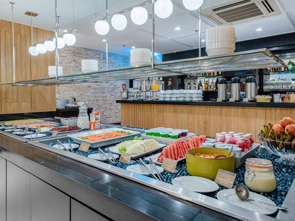 a buffet line with many different types of food at Hotel Cassino Tower Campinas Cambuí By Nacional Inn in Campinas
