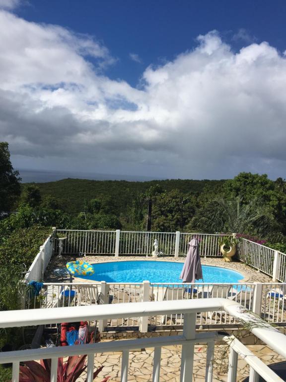 Una vista de una piscina desde un balcón. en La Nicotoria Apartments, en Deshaies