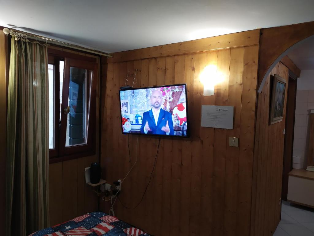 een televisie aan de muur van een slaapkamer bij sweet venice apartment in Venetië