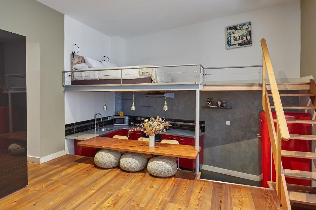 a room with a table and bunk beds at Loft - L'Hôtel Particulier in Bordeaux