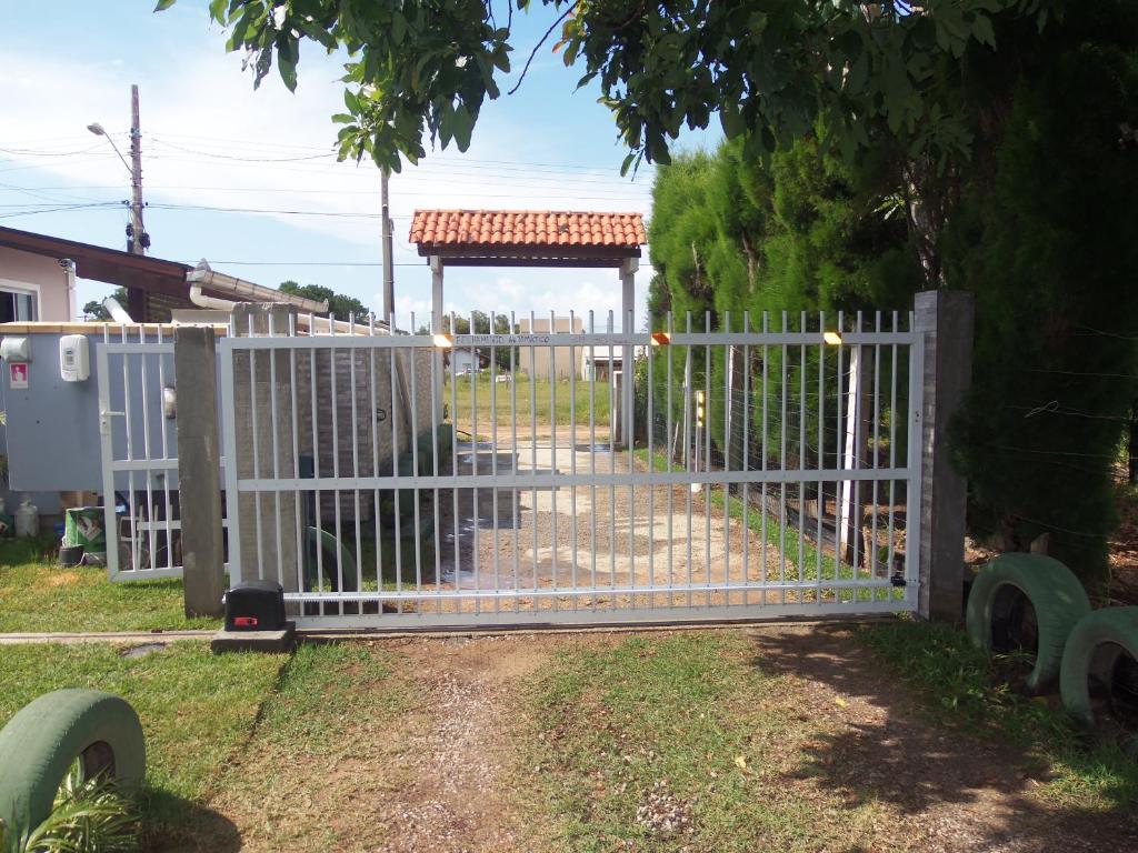 a white fence with a gate in a yard at Recanto Dos Vargas in Florianópolis