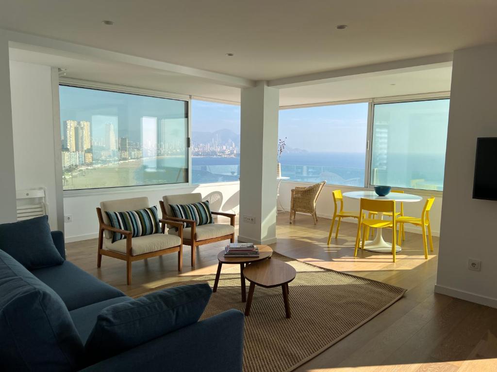 un soggiorno con divano, sedie e tavolo di Amazing beachfront apartment - La Cala a Benidorm
