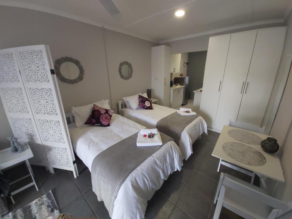 a room with two beds and a table in it at Bliss on the bay in Richards Bay