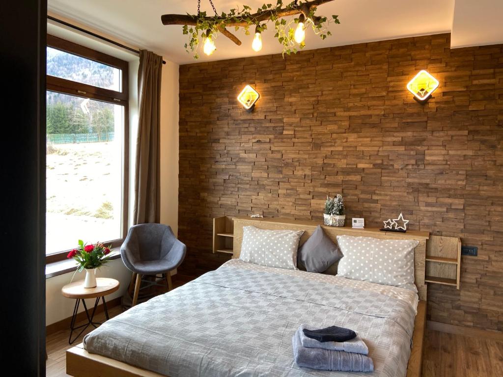 a bedroom with a bed and a brick wall at TOP3 in Predeluţ