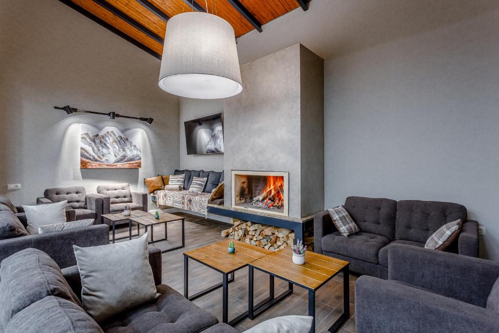 a living room with couches and a fireplace at Hotel Tsiga in Gudauri