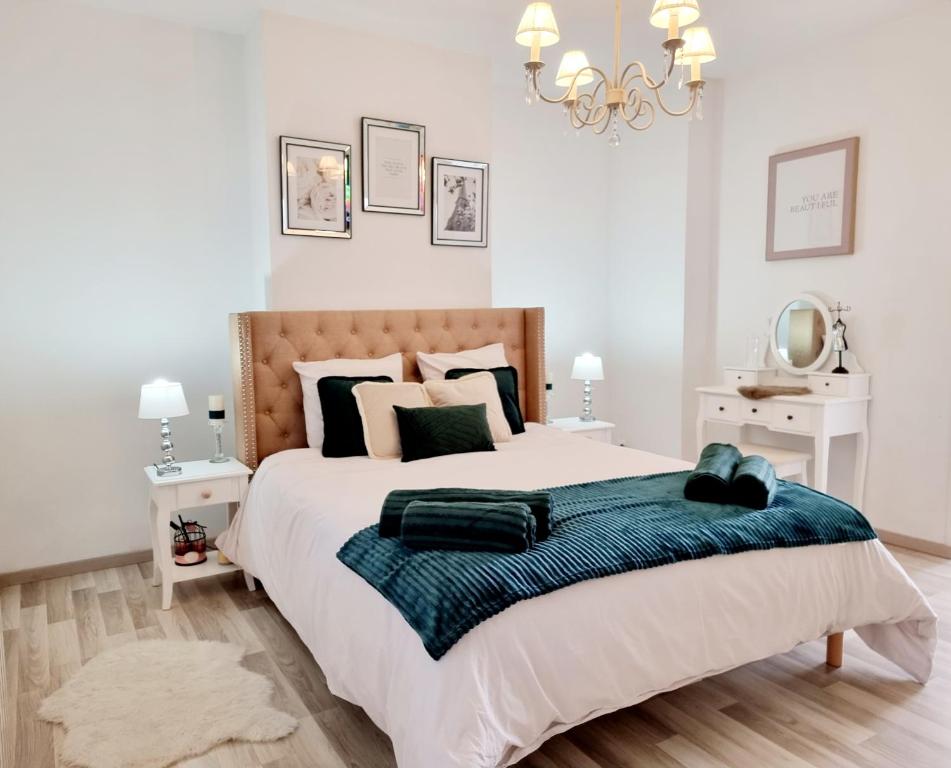 1 dormitorio con 1 cama grande con manta azul en Oasis Citadine Terrasse intime jardin privatif en plein centre ville 70m2, en Cambrai