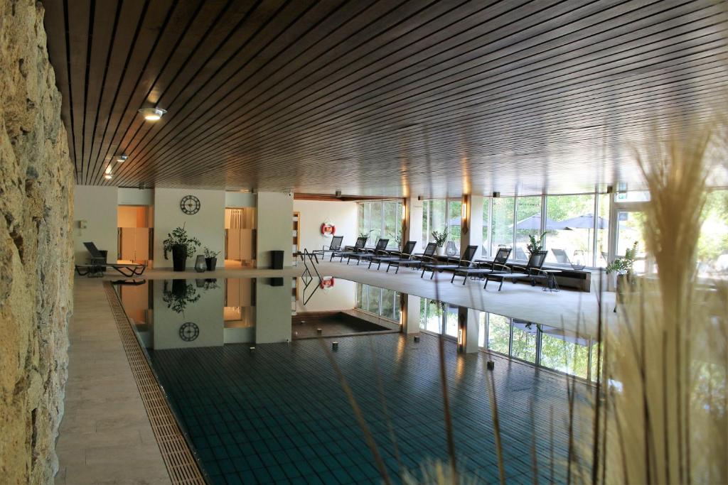 un vestíbulo con sillas y una piscina en un edificio en Hotel Kaiseralm en Bischofsgrün