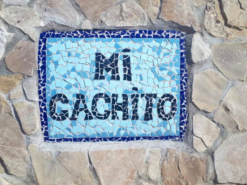 a blue mosaic sign on a stone wall at Mi Cachito in Los Caños de Meca