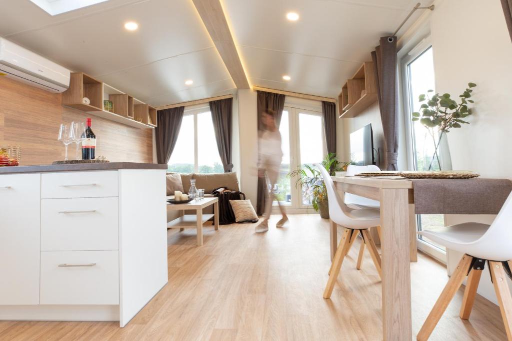 a kitchen and living room with a table and chairs at gemütliches, voll ausgestattes Tiny House in Vilseck