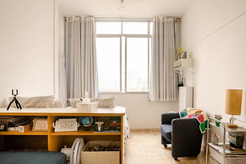 um quarto com uma secretária, uma cadeira e uma janela em Studio no Largo da Carioca - Rio de Janeiro no Rio de Janeiro
