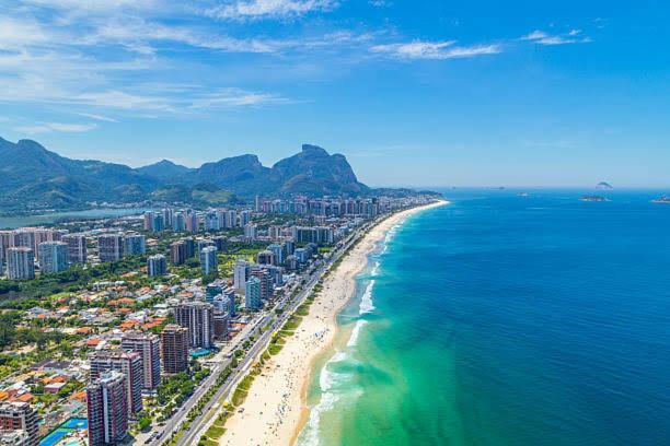 eine Luftansicht auf einen Strand mit Gebäuden und das Meer in der Unterkunft Maravilhoso Apartamento com 4 quartos Praia da Barra da Tijuca in Rio de Janeiro