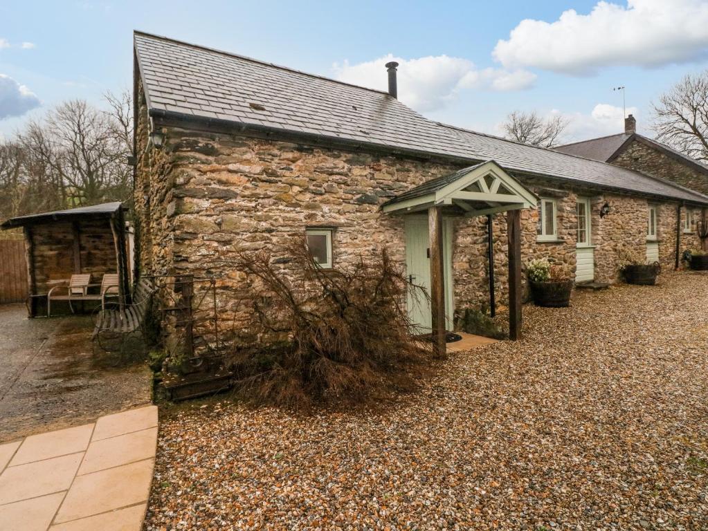 an old stone house with a roof at Old Tether Barn in Whitechurch