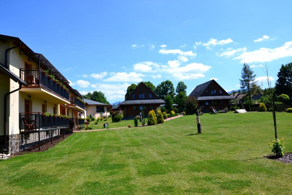 un gran patio con casas al fondo en Sojka Resort - Hotel & Drevenice, en Bešeňová