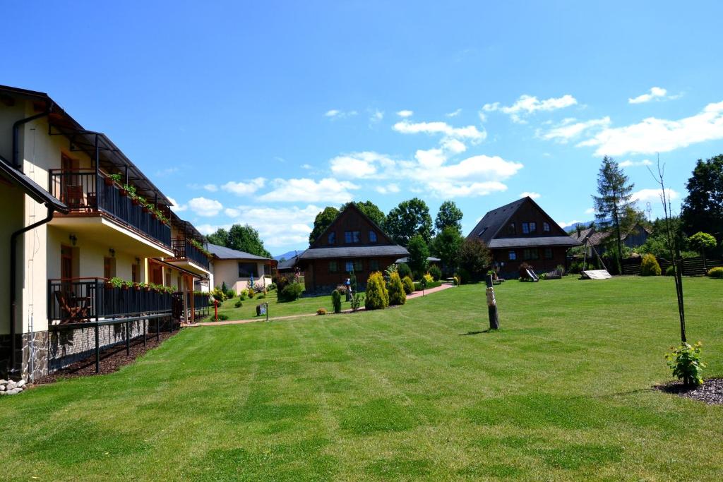 a large yard with houses in the background at Sojka Resort - Hotel & Drevenice in Bešeňová