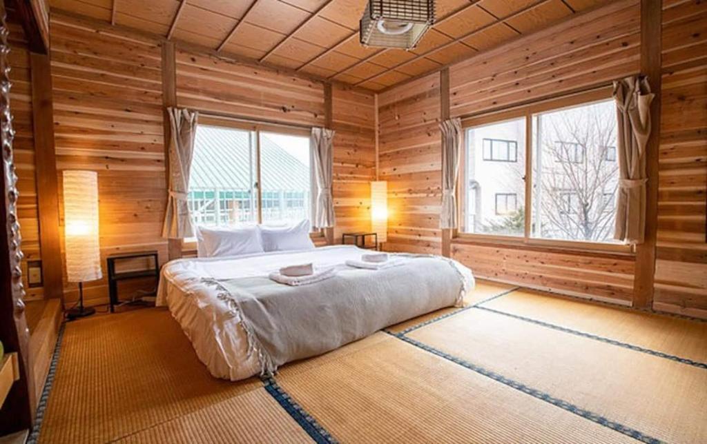 A bed or beds in a room at Gozan Lodge Myoko