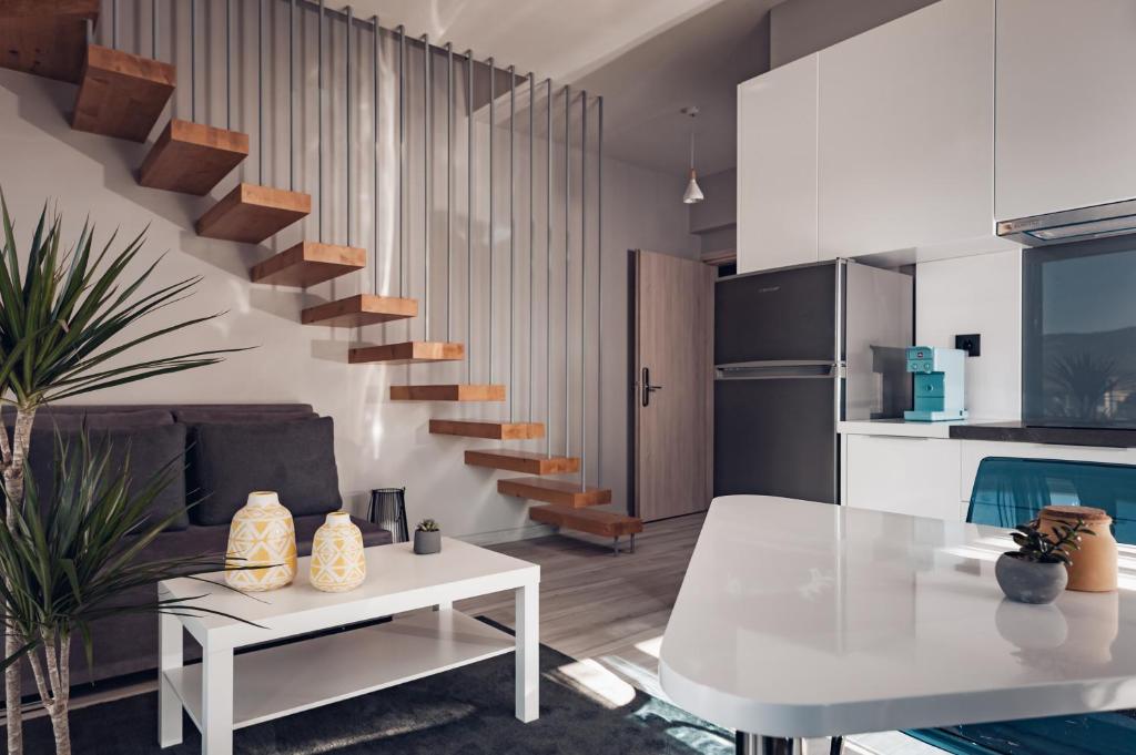 - un salon avec une table blanche et un escalier dans l'établissement DIFFERENT APARTMENTS, à Ioannina