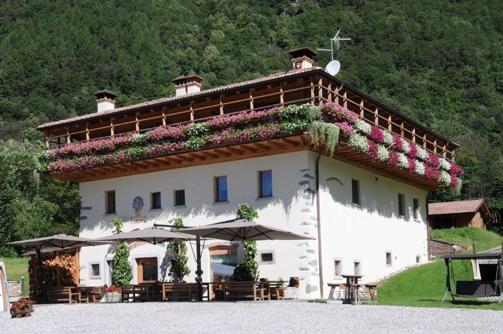a large white building with flowers on the roof at Agritur La Polentera in Storo