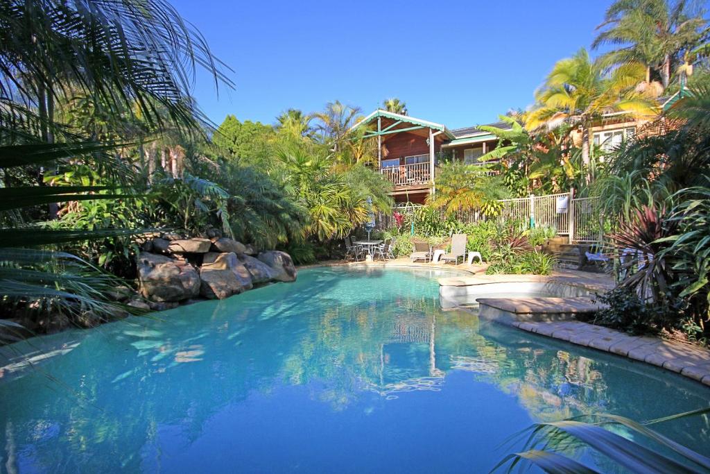 a swimming pool with blue water in a resort at Oasis Inn Ulladulla in Ulladulla