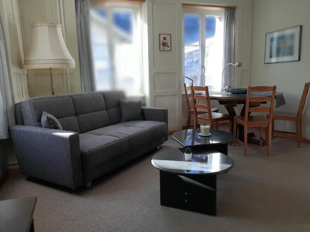 a living room with a couch and a table at Ferienwohnung Rothorn Meiringen in Meiringen