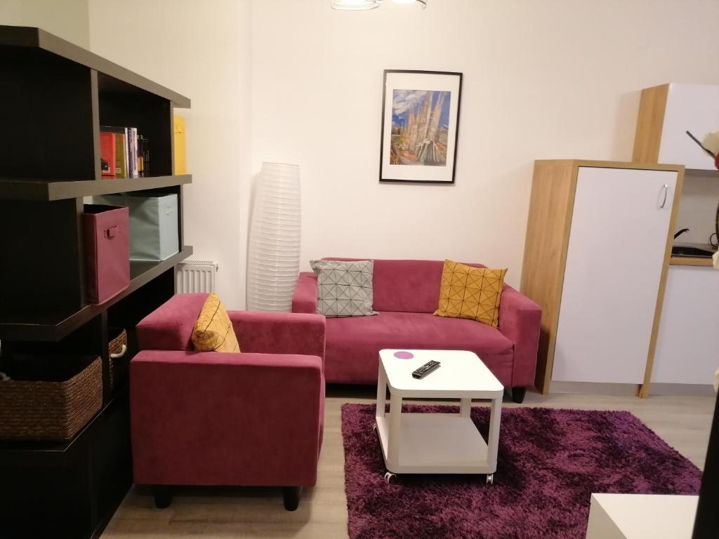 een woonkamer met een paarse bank en een tafel bij Studio 28 - 1 camera Lazăr Residence ultracentral in Iaşi