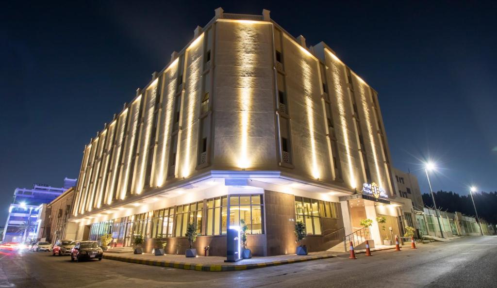 un gran edificio con luces encendidas por la noche en Iris Boutique Taif Heart en Taif