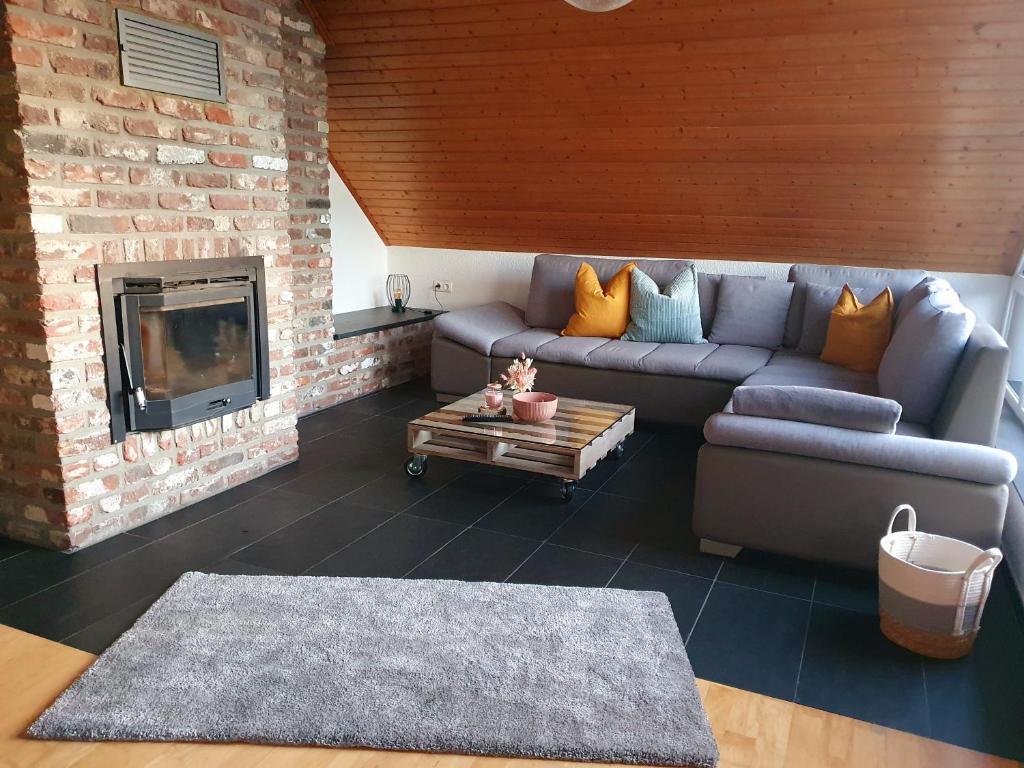 sala de estar con sofá y chimenea en Fewo Eifelhöhe en Kelberg