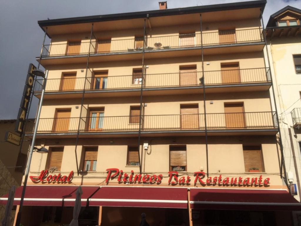 a building with a sign for a restaurant at Hostal Pirineos Ainsa in Aínsa