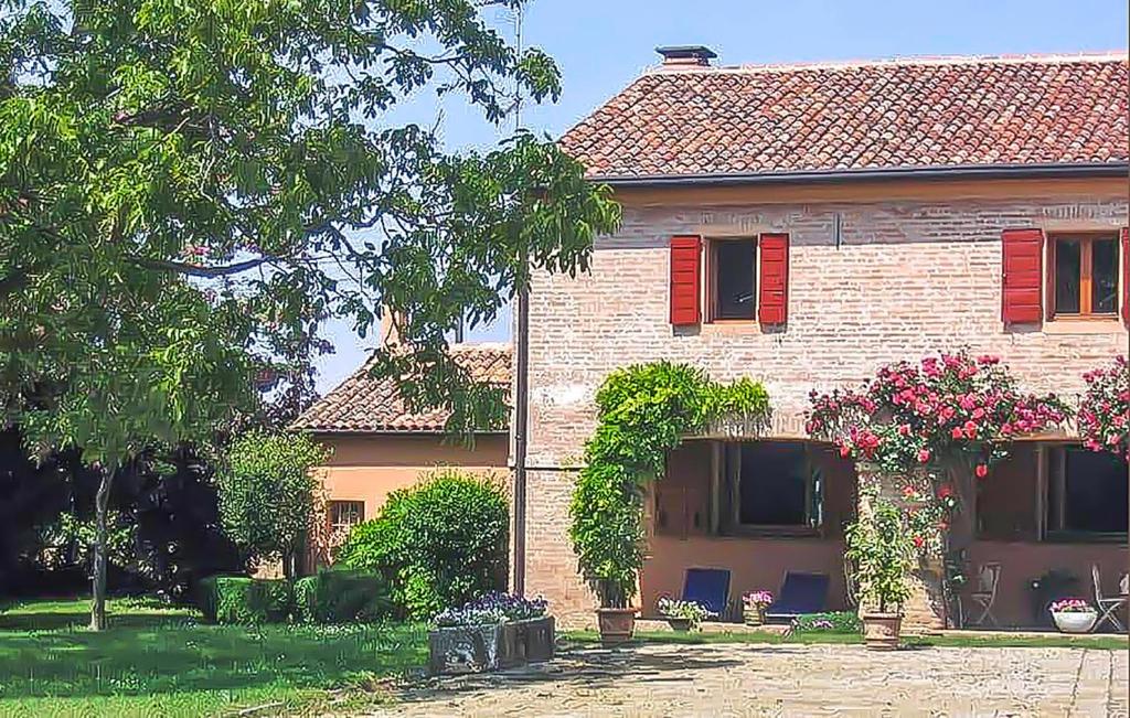 una casa de ladrillo con persianas rojas y un patio en Pet Friendly Home In Boara Pisani With Kitchen, en Boara Pisani