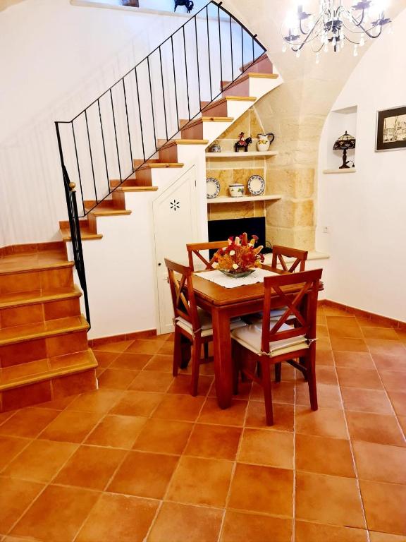 a dining room with a table and chairs and a staircase at Casa Ses Roques in Ciutadella