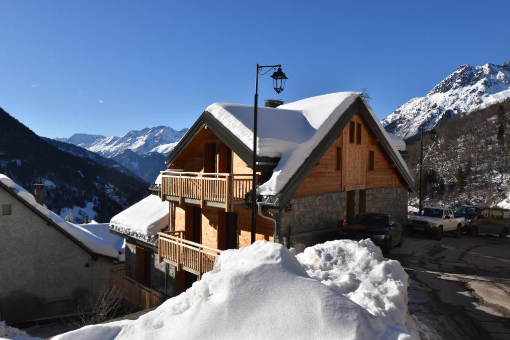 une maison recouverte de neige avec un tas de neige dans l'établissement VAUJANYLOCATIONS - Marguerite, à Vaujany