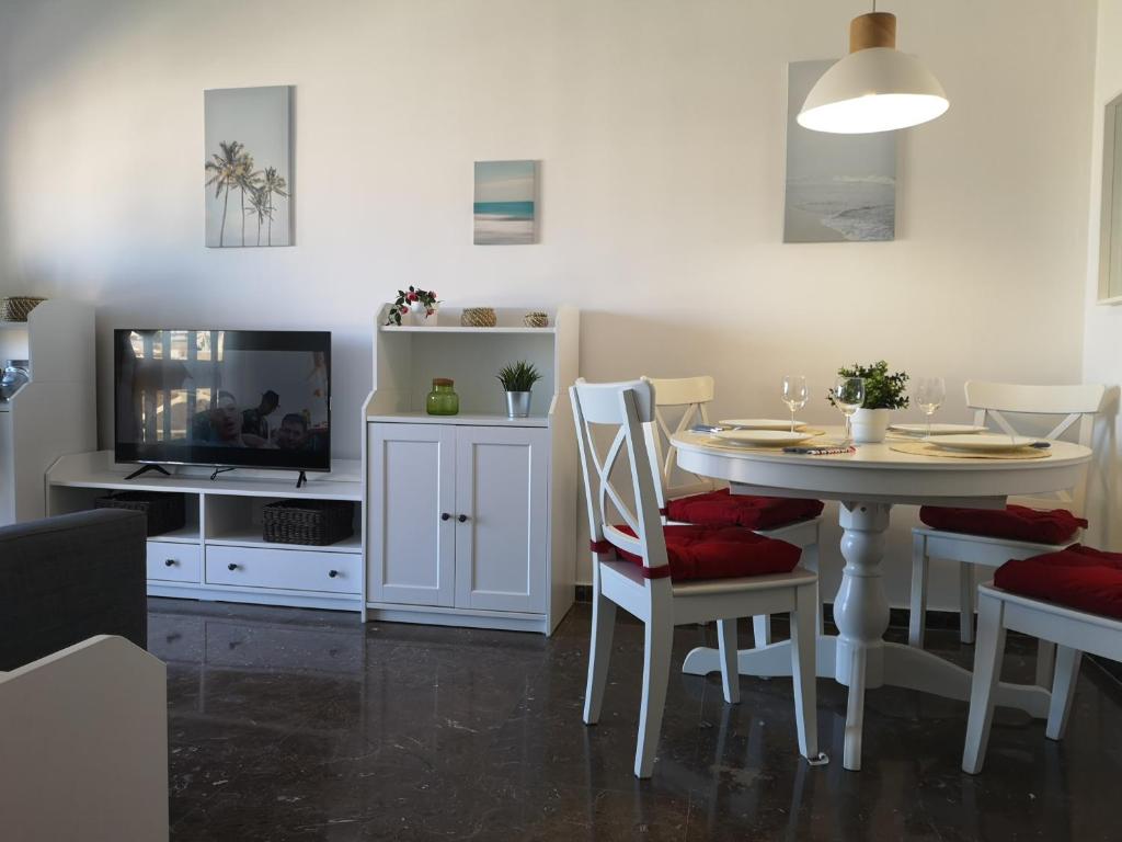 Telewizja i/lub zestaw kina domowego w obiekcie APARTAMENTO 1ª LINEA PLAYA GARAJE PISCINAS TERRAZA