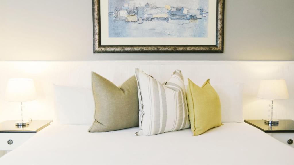 a group of pillows on a bed with a picture at Musgrave Avenue Guest Lodge in Durban